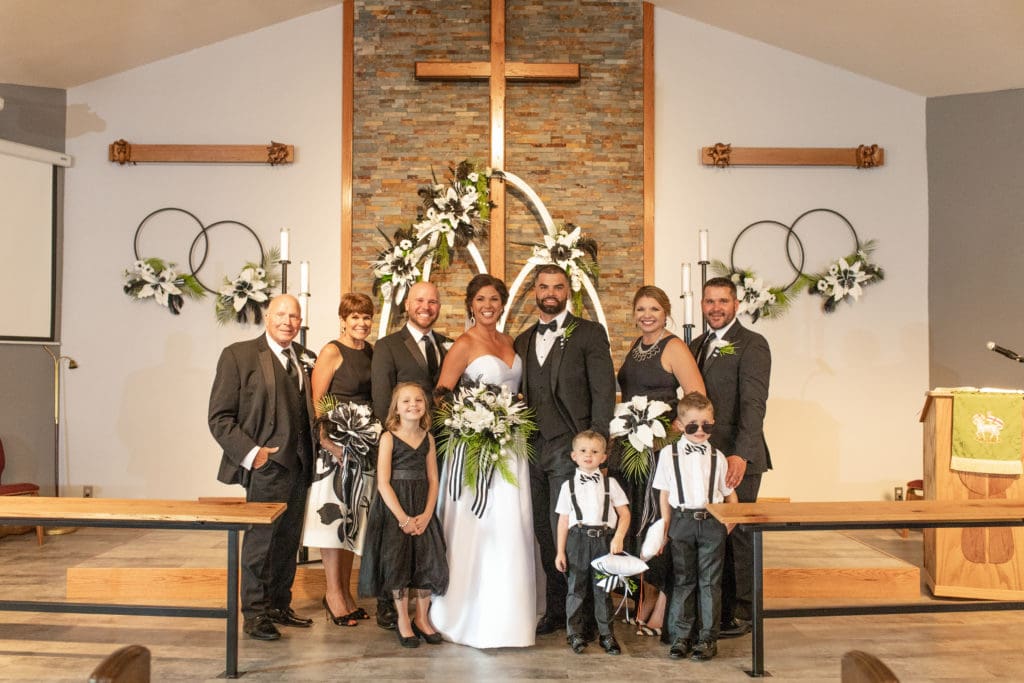 bride and groom with brides family, black tuxedos, family portraits