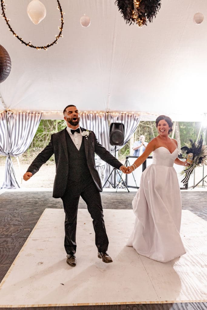  bride and groom introduced, bride and groom dancing, bride and groom laughing on dance floor, black and white outdoor wedding