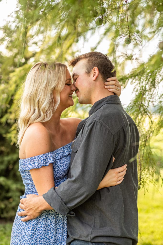 Outfits for engagement photos couple kissing outdoors under tree in Southern Illinois